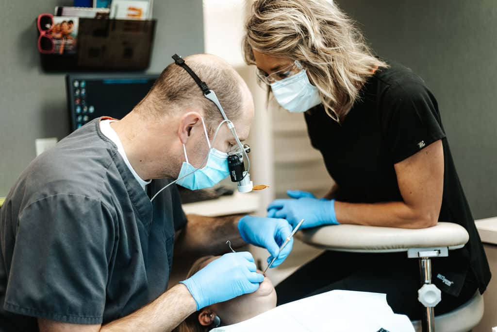 dentist and assistant working in patient's mouth